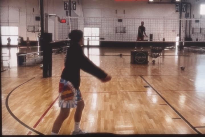 An athlete passing a serve on an indoor court